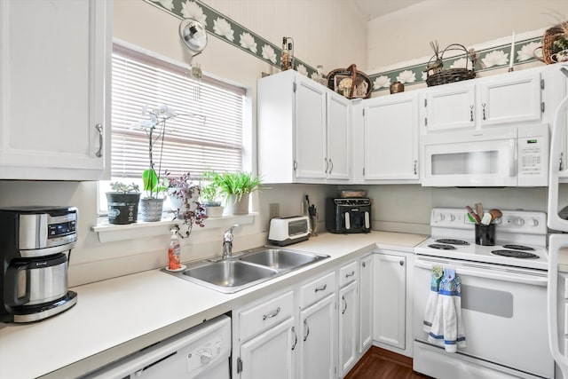 kitchen with a sink, white cabinets, white appliances, and light countertops