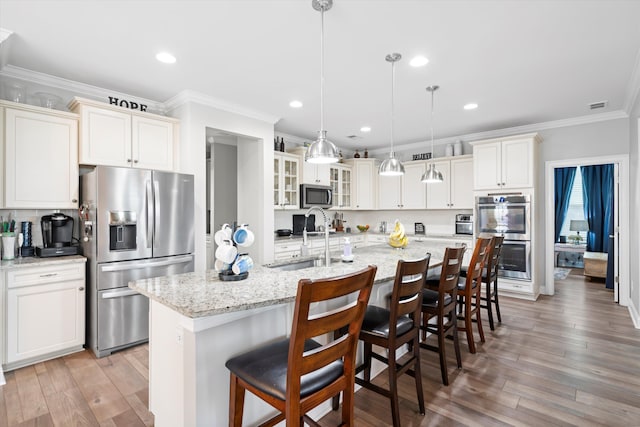 451 Spectrum Rd, Summerville, SC 29486 - kitchen featuring appliances with stainless steel finishes, ornamental molding, glass insert cabinets, a sink, and a breakfast bar area