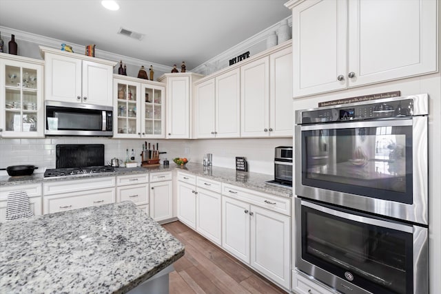 451 Spectrum Rd, Summerville, SC 29486 - kitchen with appliances with stainless steel finishes, crown molding, decorative backsplash, light wood-type flooring, and glass insert cabinets