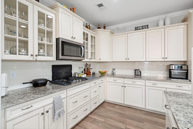 451 Spectrum Rd, Summerville, SC 29486 - kitchen featuring appliances with stainless steel finishes, decorative backsplash, ornamental molding, light wood-style floors, and glass insert cabinets