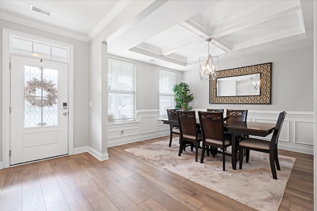 451 Spectrum Rd, Summerville, SC 29486 - dining area with a chandelier, a decorative wall, a wainscoted wall, wood finished floors, and crown molding