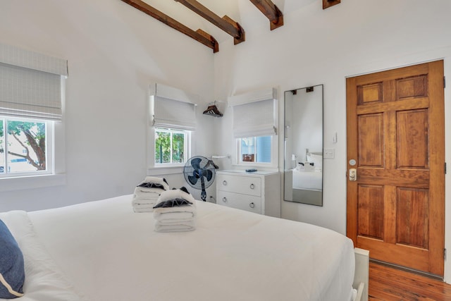 bedroom featuring beamed ceiling and hardwood / wood-style flooring