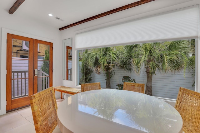 tiled dining space featuring beamed ceiling and french doors