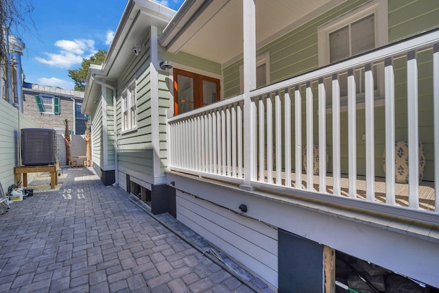 view of side of property with cooling unit and a patio