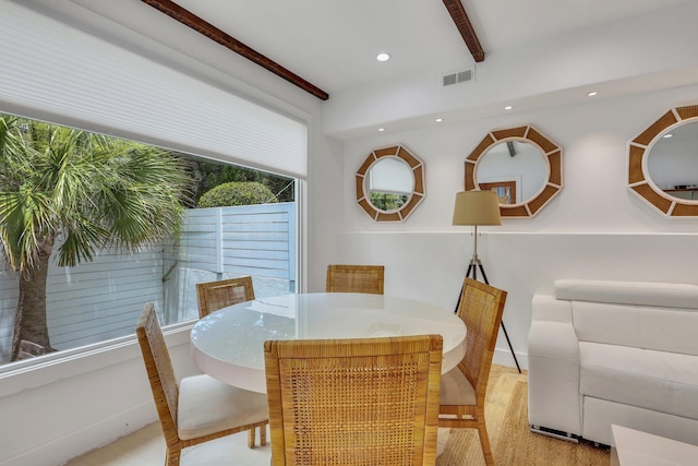 dining area featuring beamed ceiling and light hardwood / wood-style flooring