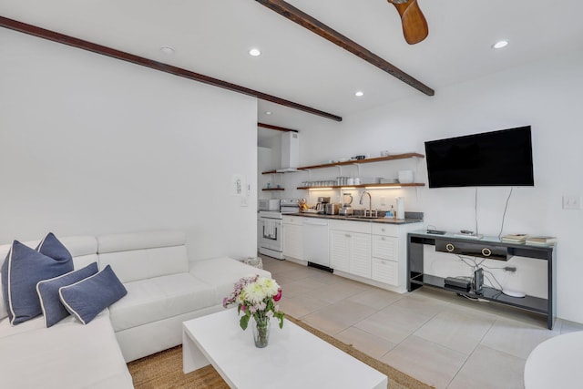 tiled living room featuring ceiling fan, sink, and beam ceiling