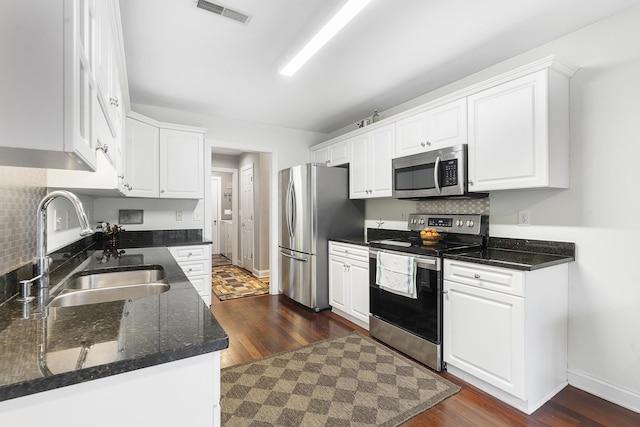 kitchen with visible vents, backsplash, appliances with stainless steel finishes, white cabinets, and a sink