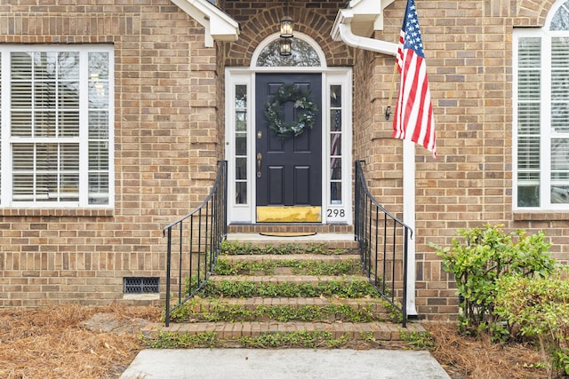 property entrance with crawl space and brick siding