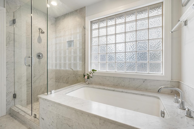 full bathroom featuring a stall shower, a healthy amount of sunlight, and a garden tub