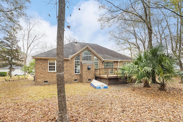 back of house featuring roof with shingles, brick siding, crawl space, and a wooden deck