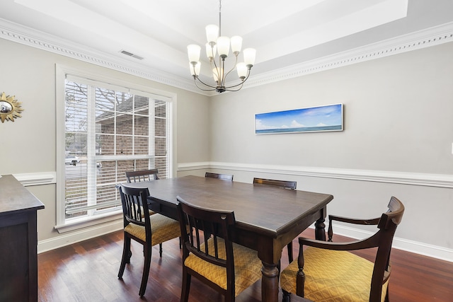 dining area with dark wood-style floors, a tray ceiling, baseboards, and an inviting chandelier