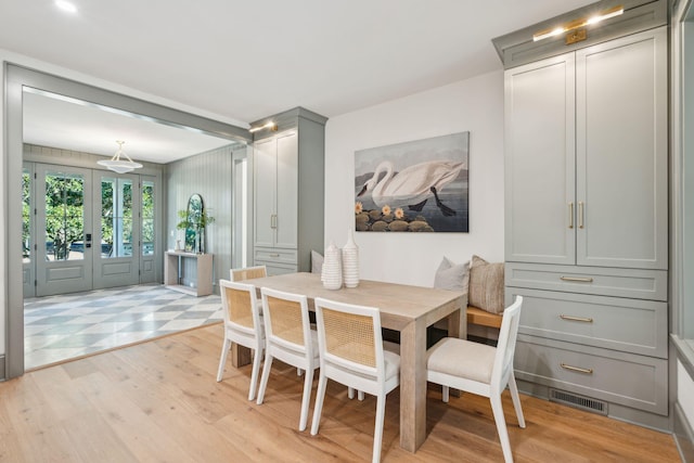 dining area with french doors and light hardwood / wood-style floors