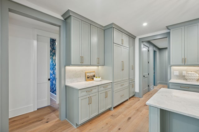 kitchen with tasteful backsplash, light wood-type flooring, and gray cabinetry