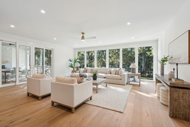 living room with ceiling fan and light hardwood / wood-style flooring