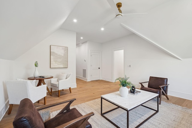 living room featuring light hardwood / wood-style floors, ceiling fan, and vaulted ceiling