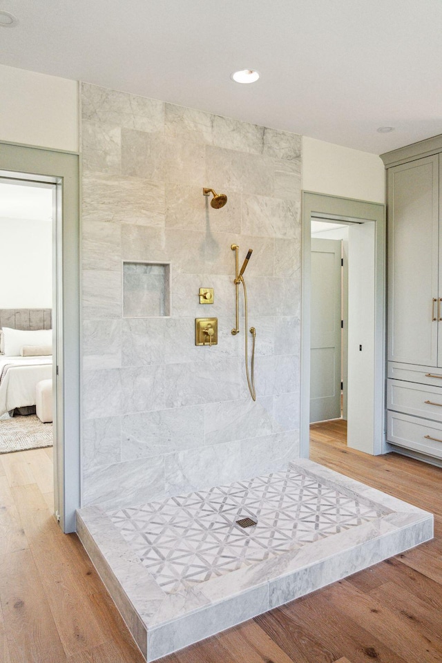 bathroom featuring hardwood / wood-style floors and a tile shower