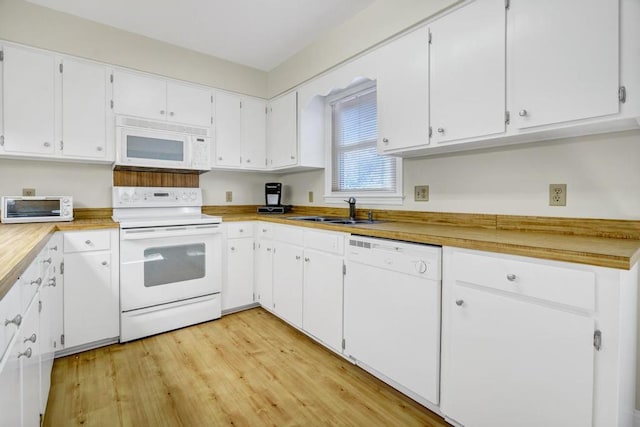 kitchen featuring white appliances, a toaster, a sink, and white cabinets