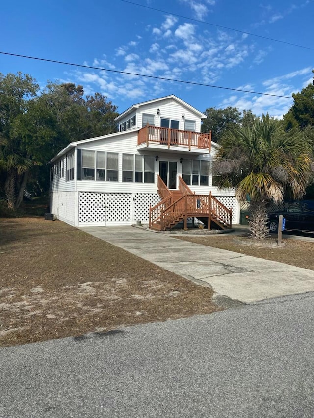 view of front of home featuring a sunroom and a balcony