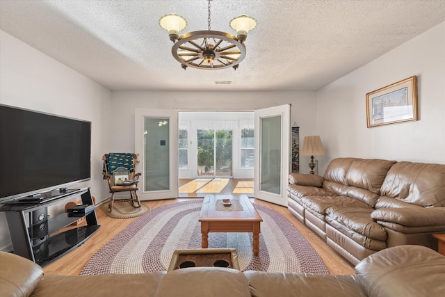 living room featuring hardwood / wood-style flooring, a textured ceiling, and french doors