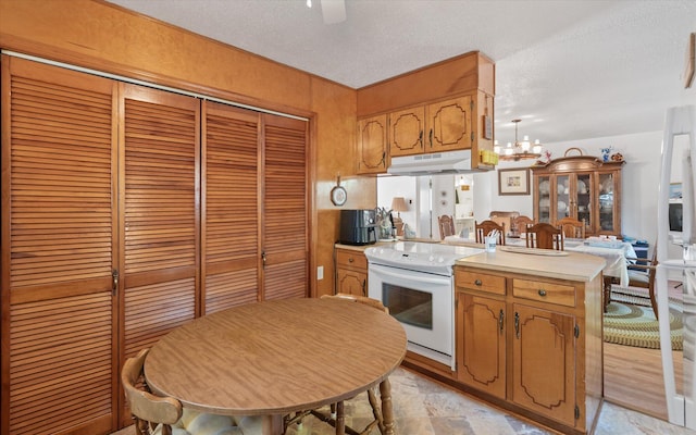 kitchen with white range with electric cooktop, a notable chandelier, and a textured ceiling