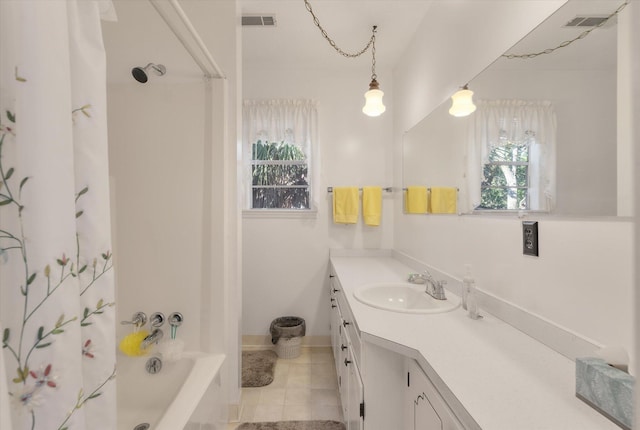 bathroom with tile patterned flooring, vanity, a healthy amount of sunlight, and shower / bath combo