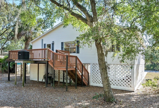 rear view of property featuring central AC and a wooden deck