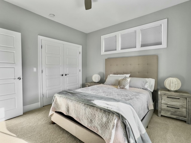 bedroom featuring ceiling fan, light carpet, and a closet