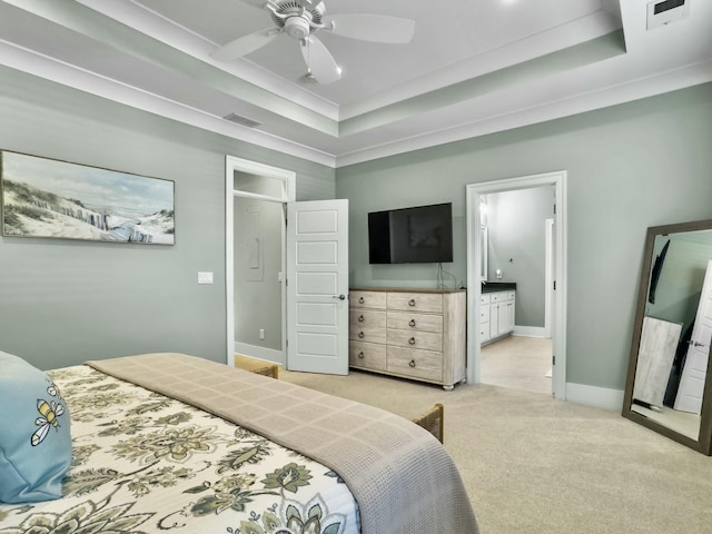 carpeted bedroom with ceiling fan, ornamental molding, connected bathroom, and a tray ceiling