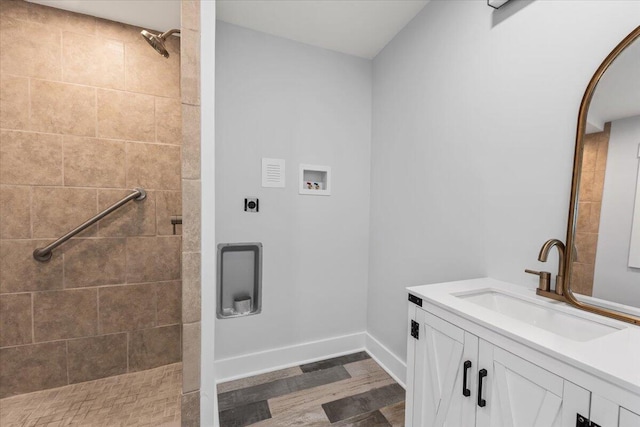 bathroom featuring vanity, hardwood / wood-style flooring, and tiled shower