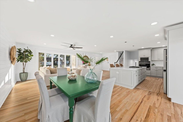 dining space with light wood-type flooring and ceiling fan