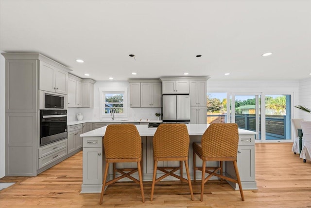 1894 Capri Dr, Charleston, SC 29407 - kitchen with wall oven, gray cabinetry, freestanding refrigerator, black microwave, and a center island