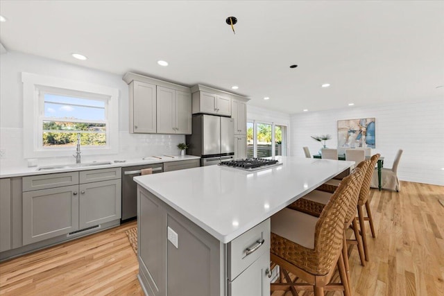 kitchen with gray cabinets, a healthy amount of sunlight, and a kitchen bar