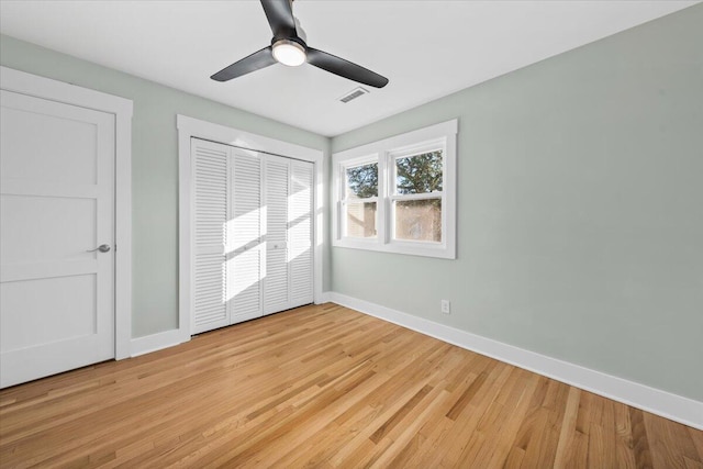 unfurnished bedroom featuring a closet, light hardwood / wood-style floors, and ceiling fan