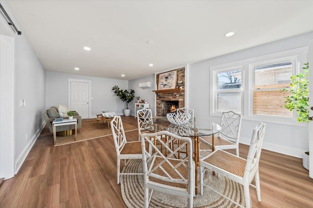 1894 Capri Dr, Charleston, SC 29407 - dining area featuring a fireplace, wood finished floors, a wall mounted air conditioner, and recessed lighting