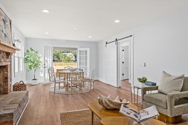 1894 Capri Dr, Charleston, SC 29407 - living area featuring a barn door, wood finished floors, a brick fireplace, and recessed lighting