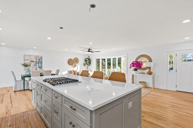 kitchen featuring gray cabinetry, a center island, light hardwood / wood-style flooring, and plenty of natural light