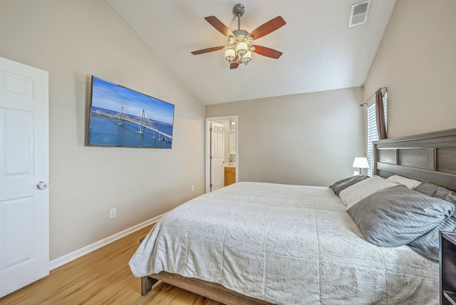 bedroom featuring wood finished floors, baseboards, visible vents, lofted ceiling, and ceiling fan