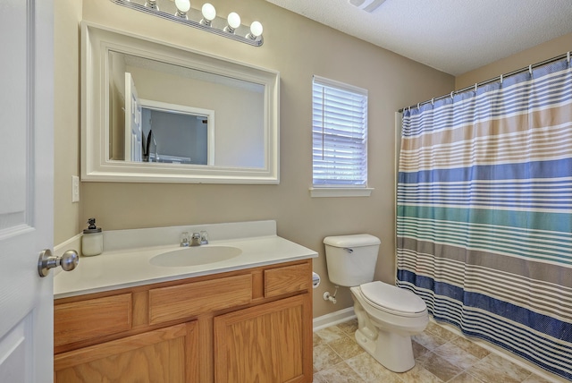 bathroom featuring vanity, baseboards, tile patterned flooring, a textured ceiling, and toilet