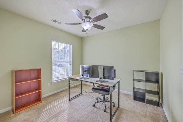 carpeted office space with visible vents, baseboards, and ceiling fan