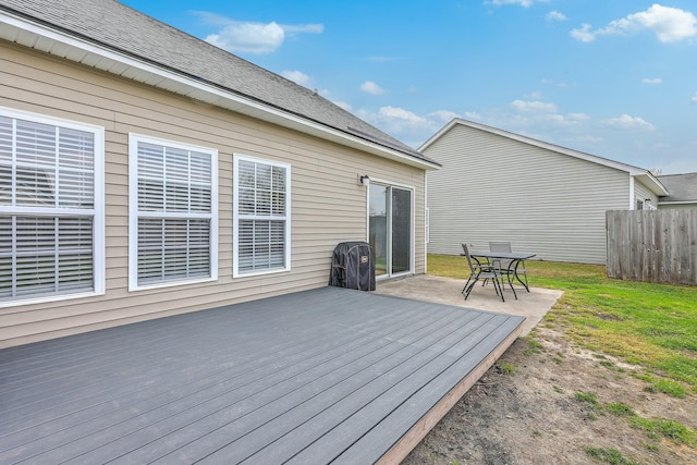 wooden deck featuring a lawn and fence