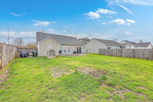 back of house with a lawn and a fenced backyard