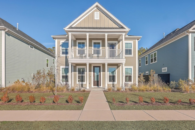 view of front facade featuring a front lawn, a balcony, and covered porch