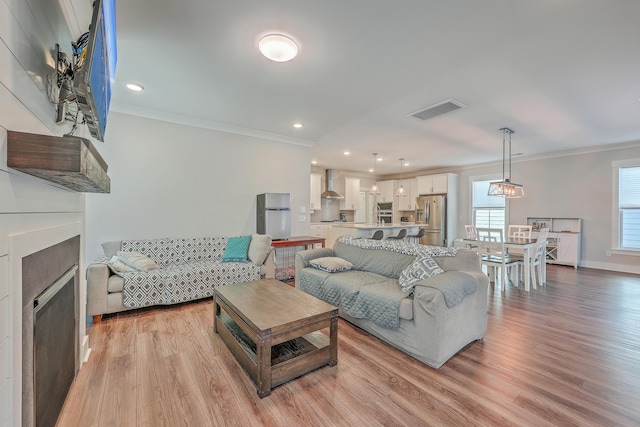 living room featuring light wood-type flooring and ornamental molding