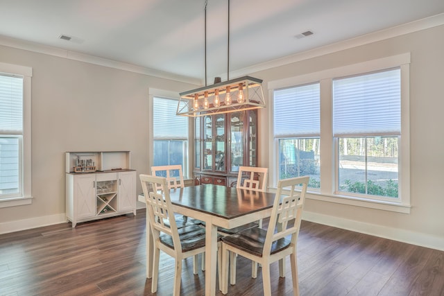 dining area with ornamental molding and dark hardwood / wood-style floors