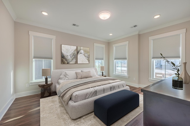 bedroom with multiple windows, dark hardwood / wood-style floors, and ornamental molding