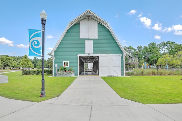 view of front of house featuring a front lawn and an outbuilding