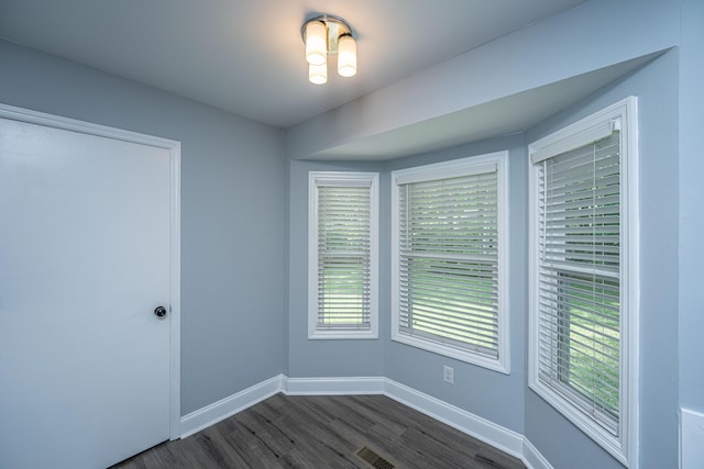 unfurnished room with dark wood-type flooring and baseboards
