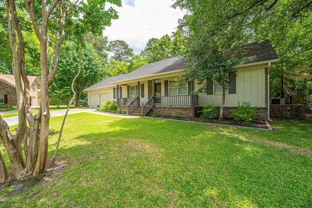 ranch-style house with a porch, a garage, concrete driveway, board and batten siding, and a front lawn