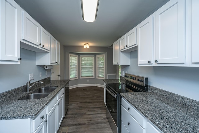kitchen with stainless steel appliances, a sink, white cabinetry, dark wood-style flooring, and dark stone counters