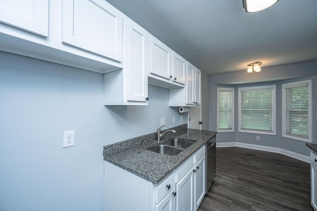 kitchen featuring a sink, dishwasher, white cabinetry, baseboards, and dark wood finished floors